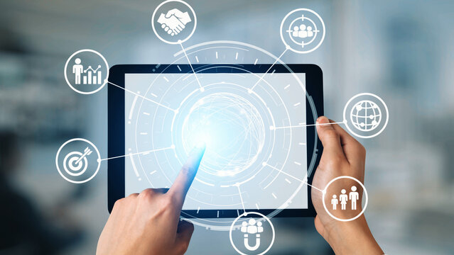 Hands holding a tablet with a glowing central interface, surrounded by connected icons for targeting, analytics, teamwork, global reach, and customer engagement—illustrating a data-driven, strategic approach to modern B2B marketing and business growth.